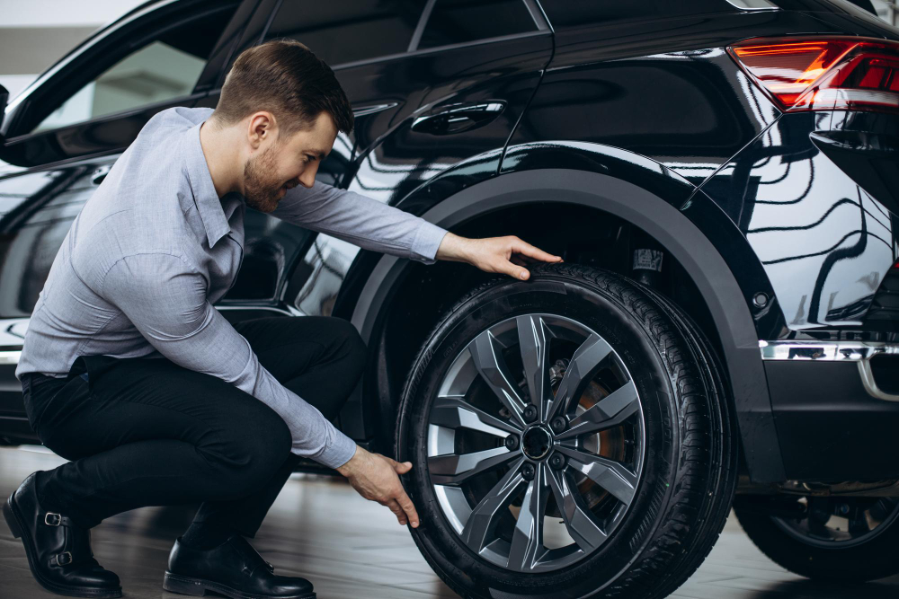 man choosing car checking tires