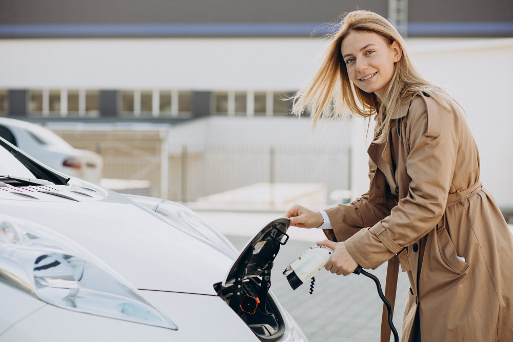 young woman charging her electric car with charging pistol