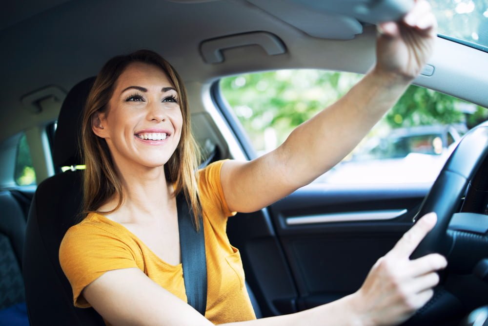 car interior view female woman driver adjusting mirrors before driving car